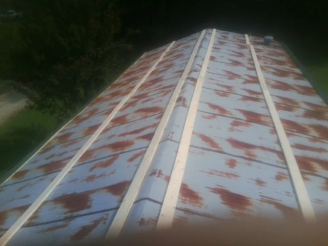 Rusted metal roof panels with new wood purlins before replacement — Storm Damage Roof Repair in Curtice by Roofing Brothers