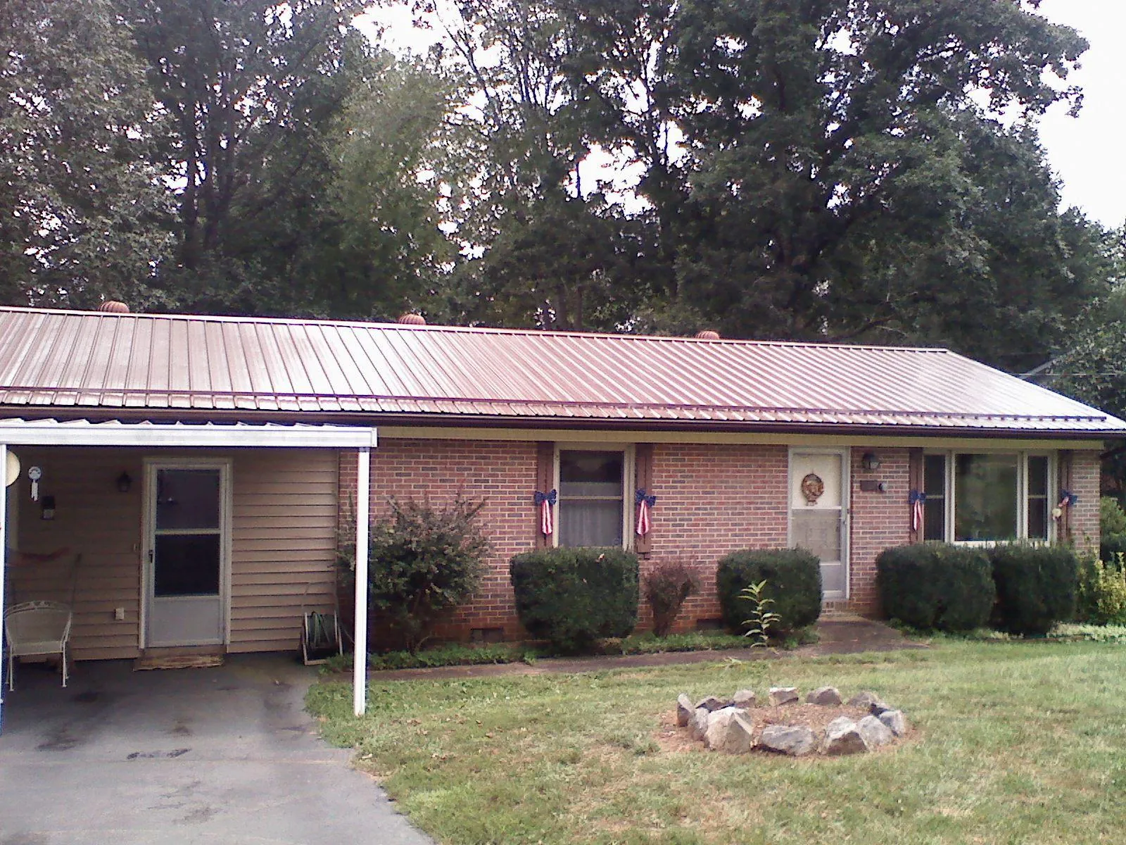 Bronze metal roof and carport on a brick ranch home — Roof Repair work by our crew in Curtice